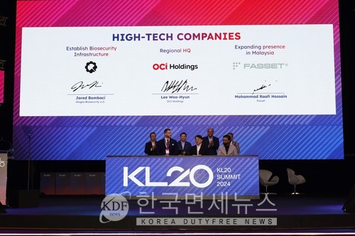 21일 KL20에서 OC홀딩스 이우현 회장(앞줄 가운데)이 업무협약식에서 서명을 하고 있다.