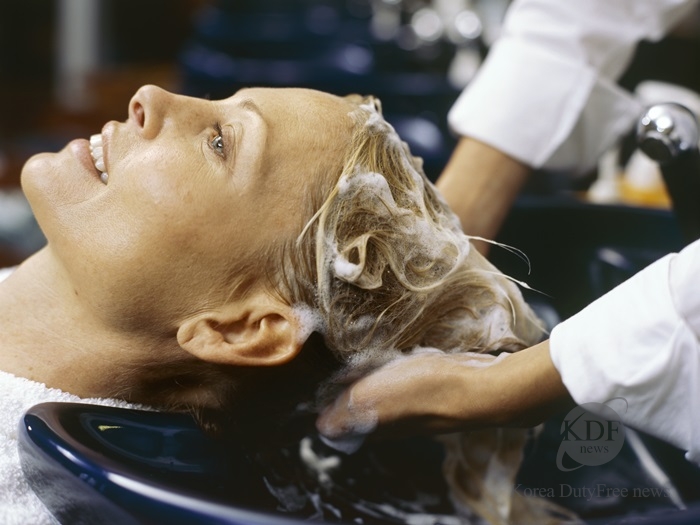 Close-up of a hairdresser shampooing a young woman/s hair