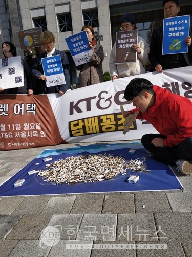 담배꽁초로 속이 가득찬 물고기를 먹는 사람의 모습을 퍼포먼스로 펼치고 있는 서울환경운동연합.