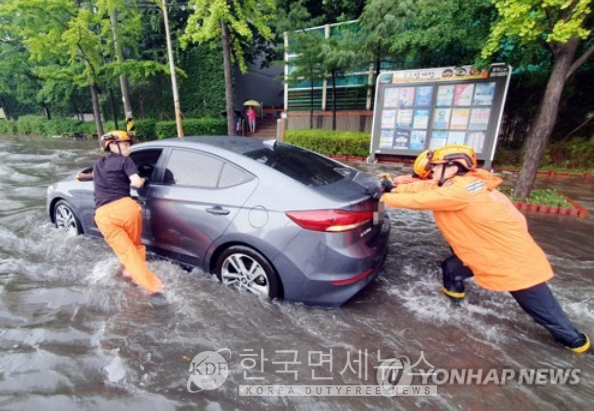 지난 8일 폭우가 내린 인천시 미추홀구 용현동 한 도로에서 소방대원들이 침수된 차량을 안전한 곳으로 옮기고 있다.(사진=연합뉴스)