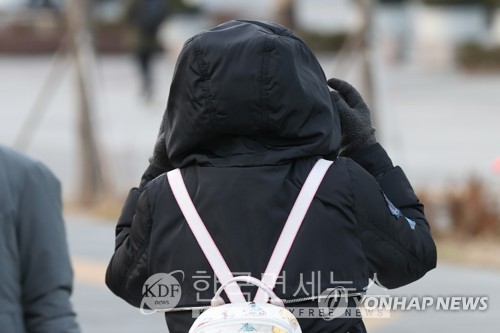 아침 기온이 낮아진 지난달 20일 오전 서울 광화문네거리에서 한 시민이 외투에 달린 모자를 만지고 있다. 연합뉴스