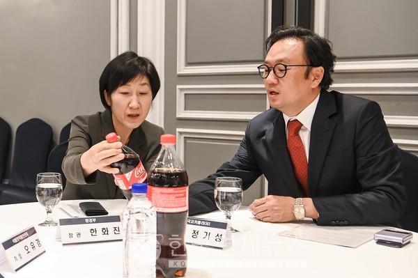 환경부 한화진 장관이 코카-콜라 재생 보틀 1.25L 시제품을 들고 한국 코카-콜라 정기성 대표와 이야기를 나누고 있다.