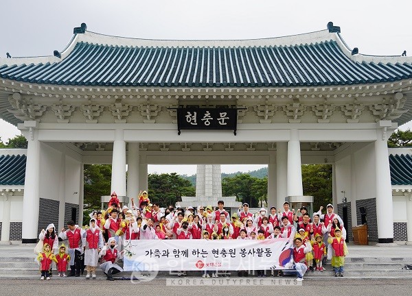 롯데건설 임직원과 가족들이 현충문 앞에서 봉사활동 후 기념촬영을 하고 있다.